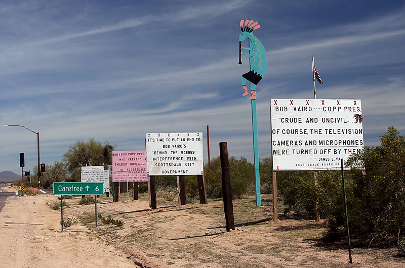 A mad man has littered his multi million dollar roadside property in north Scottsdale to make a statement against certain people about issues not readily clear from his placards