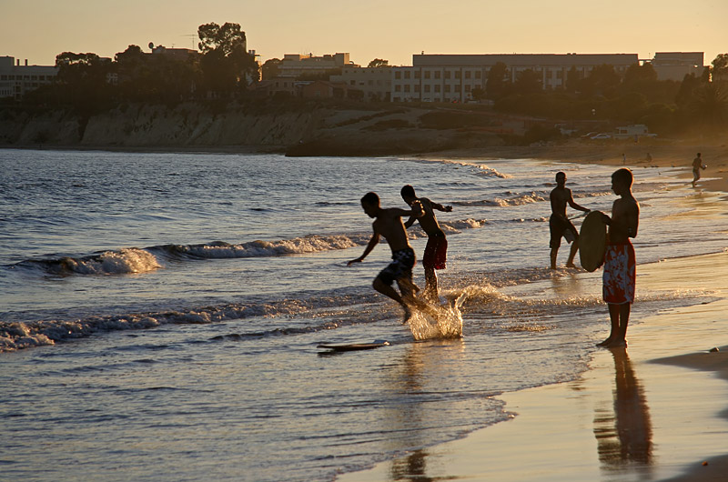 Boys playing in the Pacific ocean at the end of summer in Santa Barbara, California