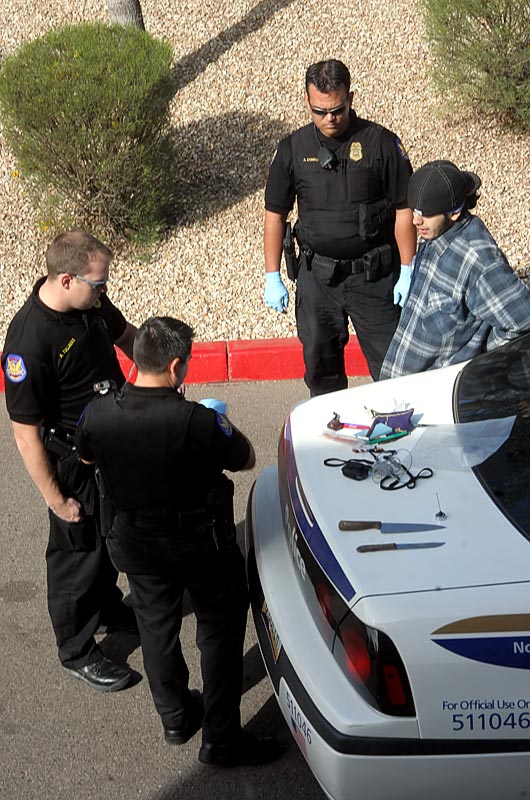 Phoenix police stopping a young man outside our window after asking him to drop the knives he was carrying