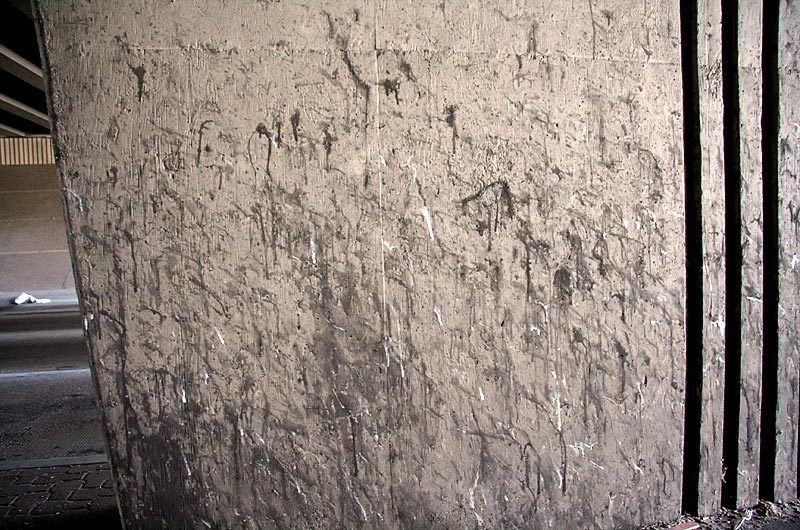 A freeway underpass support column covered with goobers of snot and spit from people, probably men, waiting at a stop light in Phoenix, Arizona