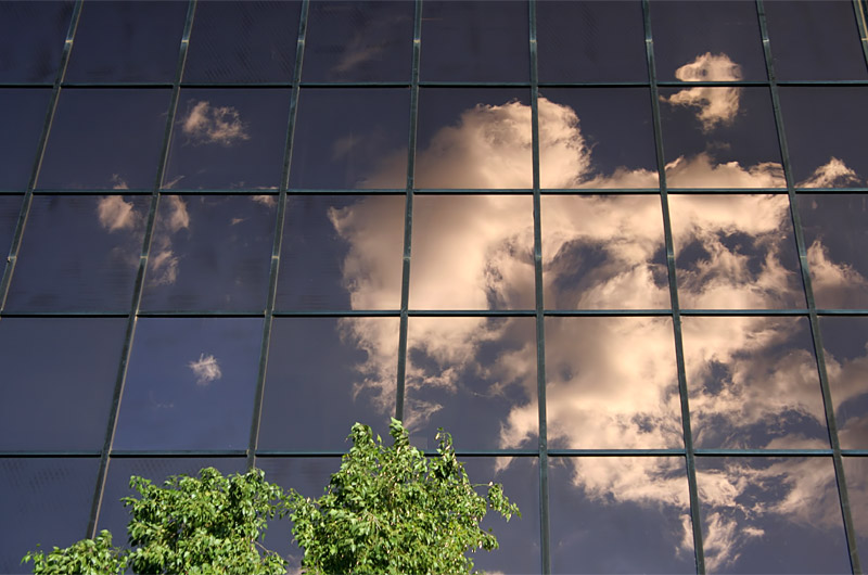 Clouds reflecting off the glass facade of a building