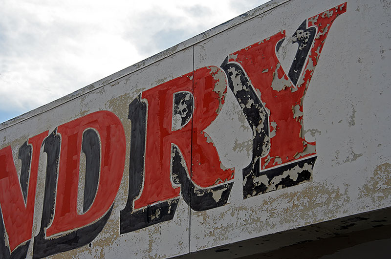 A business sign with the paint of its letters crumbling