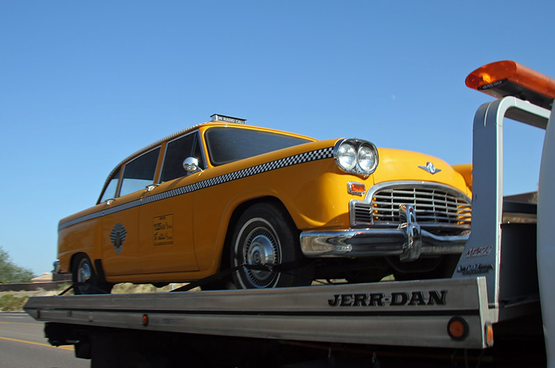 An old fashioned New York style taxi on the back of a car taxi or a tow truck, in Phoenix, Arizona