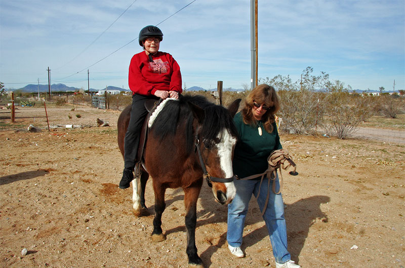 Jutta Engelhardt riding a horse at Chile Acres in Tonopah, Arizona