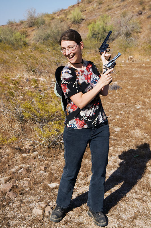 Caroline Wise posing with a .22 caliber and a .38 caliber hand gun near Saddle Mountain in Tonopah, Arizona