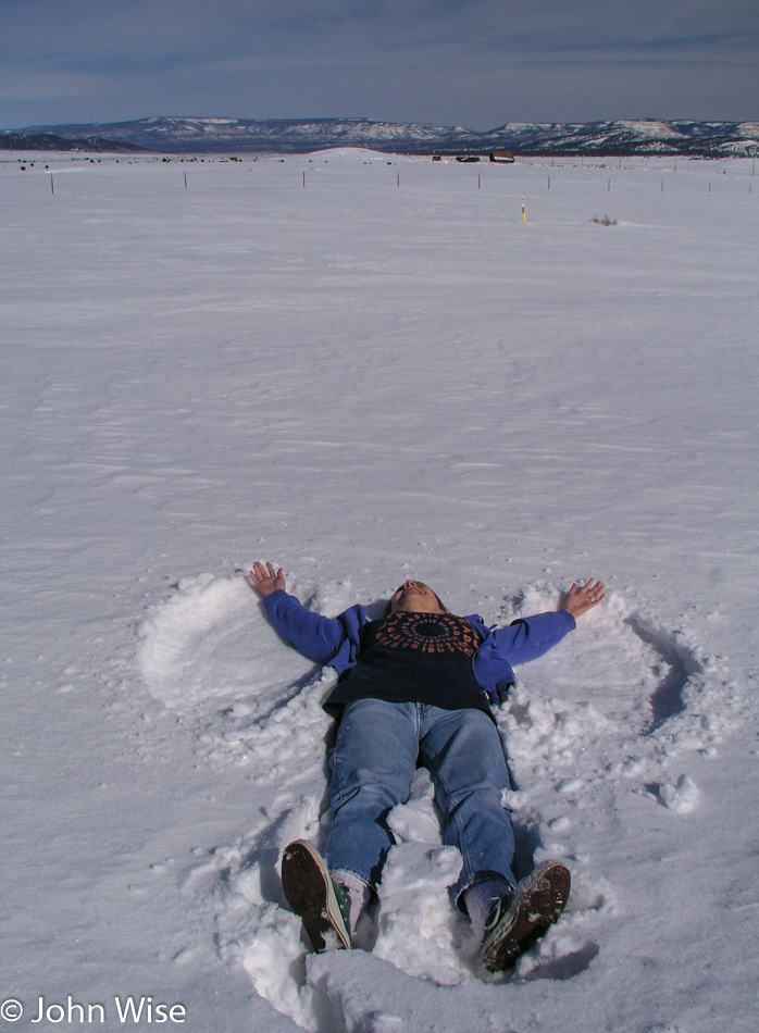 Caroline Wise making snow angels in Utah