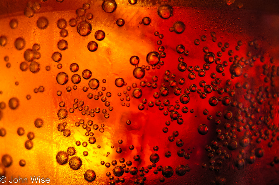 The tiny bubbles of carbonation in a plastic cup of cola at lunch