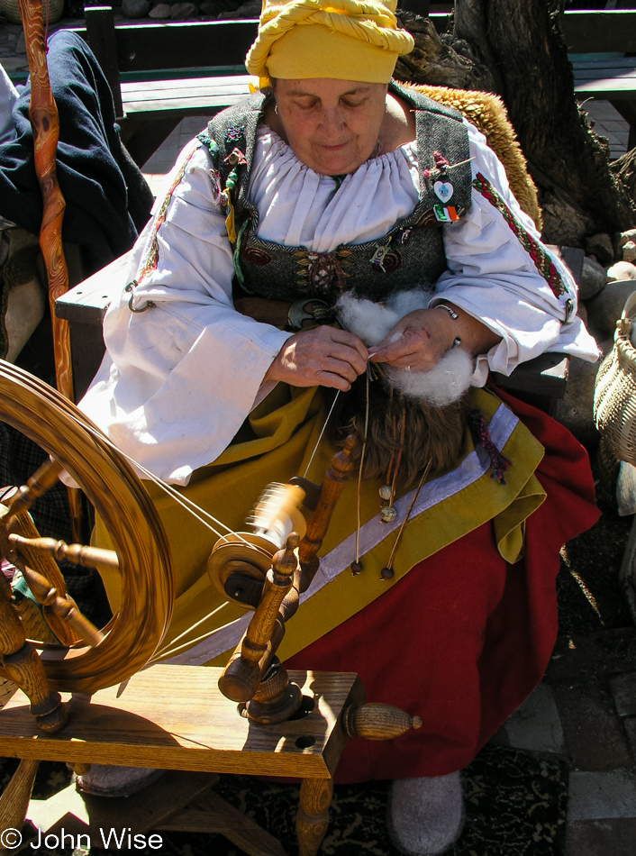 Living history example of woman spinning wool into thread at the Arizona Renaissance Festival