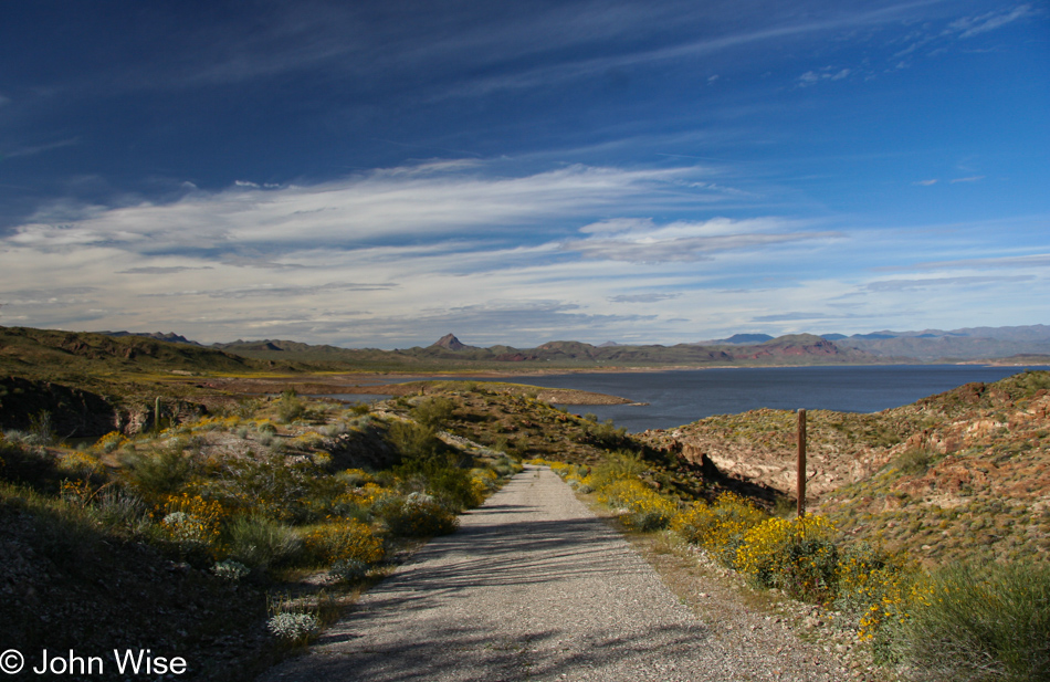 Looking down a deserted and unused road onto Alamo Lake State Park in Arizona