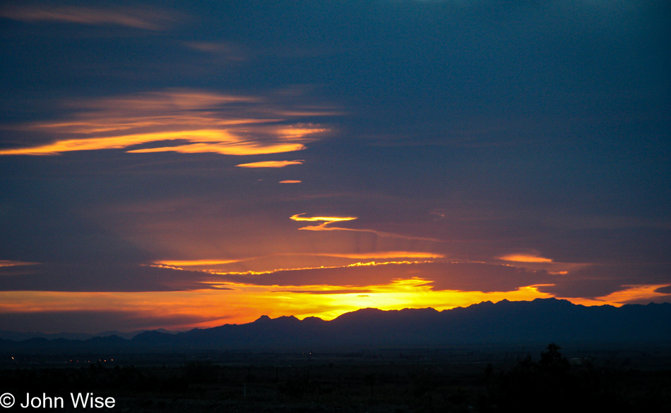 Sunset paints the early evening sky blue, purple, orange and red in the California desert