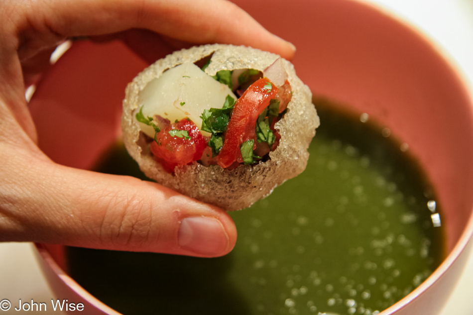 Getting ready to dip a stuffed puri into the pani