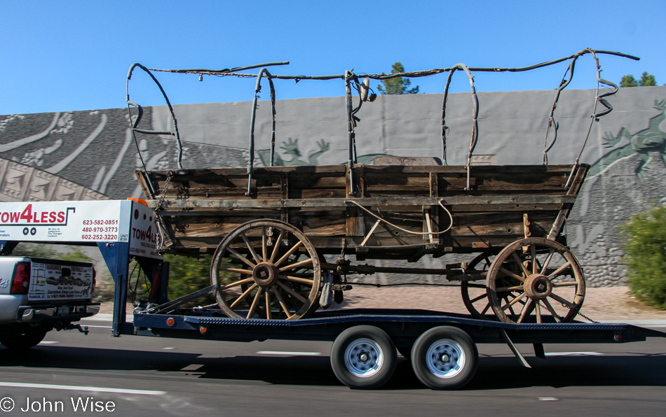 A covered wagon being towed down the freeway moving 60 miles per hour, possibly the fastest this wagon has ever moved