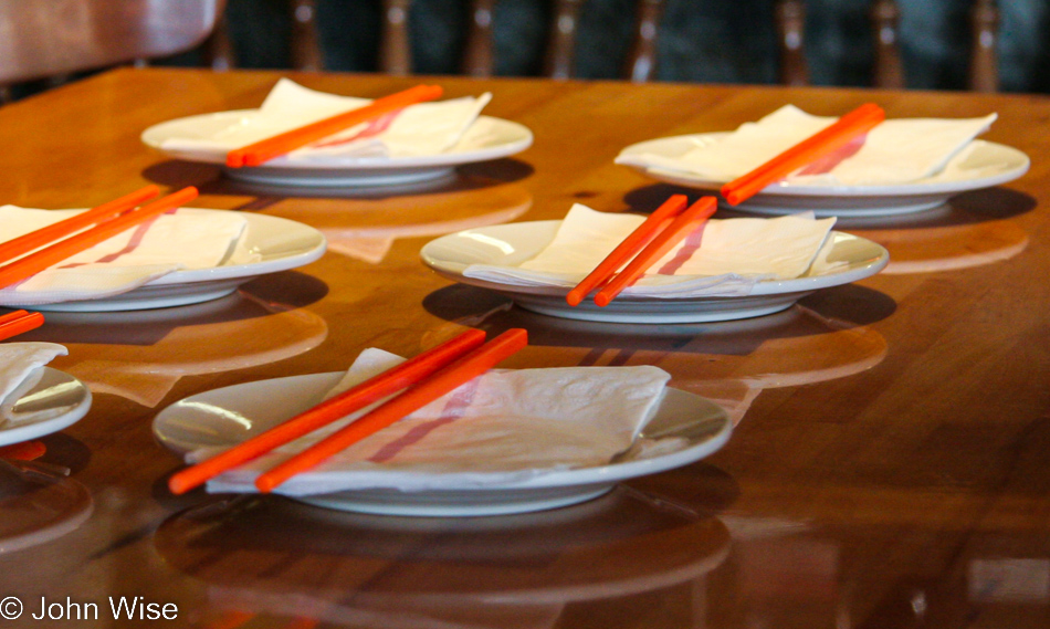 The table is set at this Asian restaurant where shiny orange chopsticks await diners