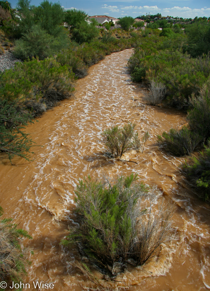 A rain-swollen wash running through Phoenix, Arizona bringing waters from the north under a hot dry sky